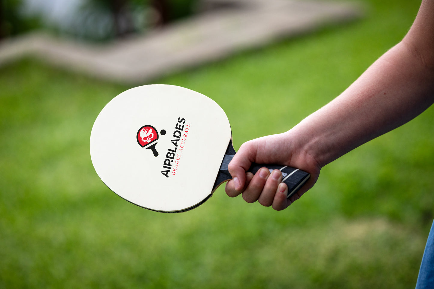 a child holding the patented slope handle for ping pong table tennis paddle by AirBlades